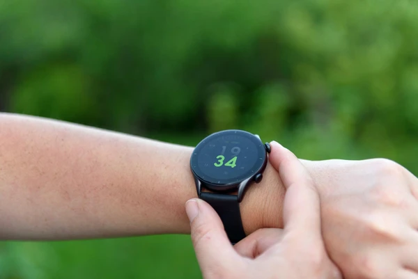Smartwatch AMOLED display visible in direct sunlight showing fitness stats
